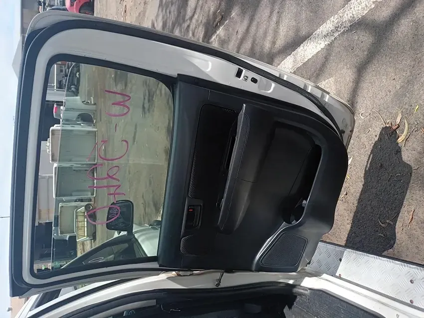 A White Car With the Door Open is Parked in a Parking Lot — South West 4WD Wreckers In Brisbane, QLD