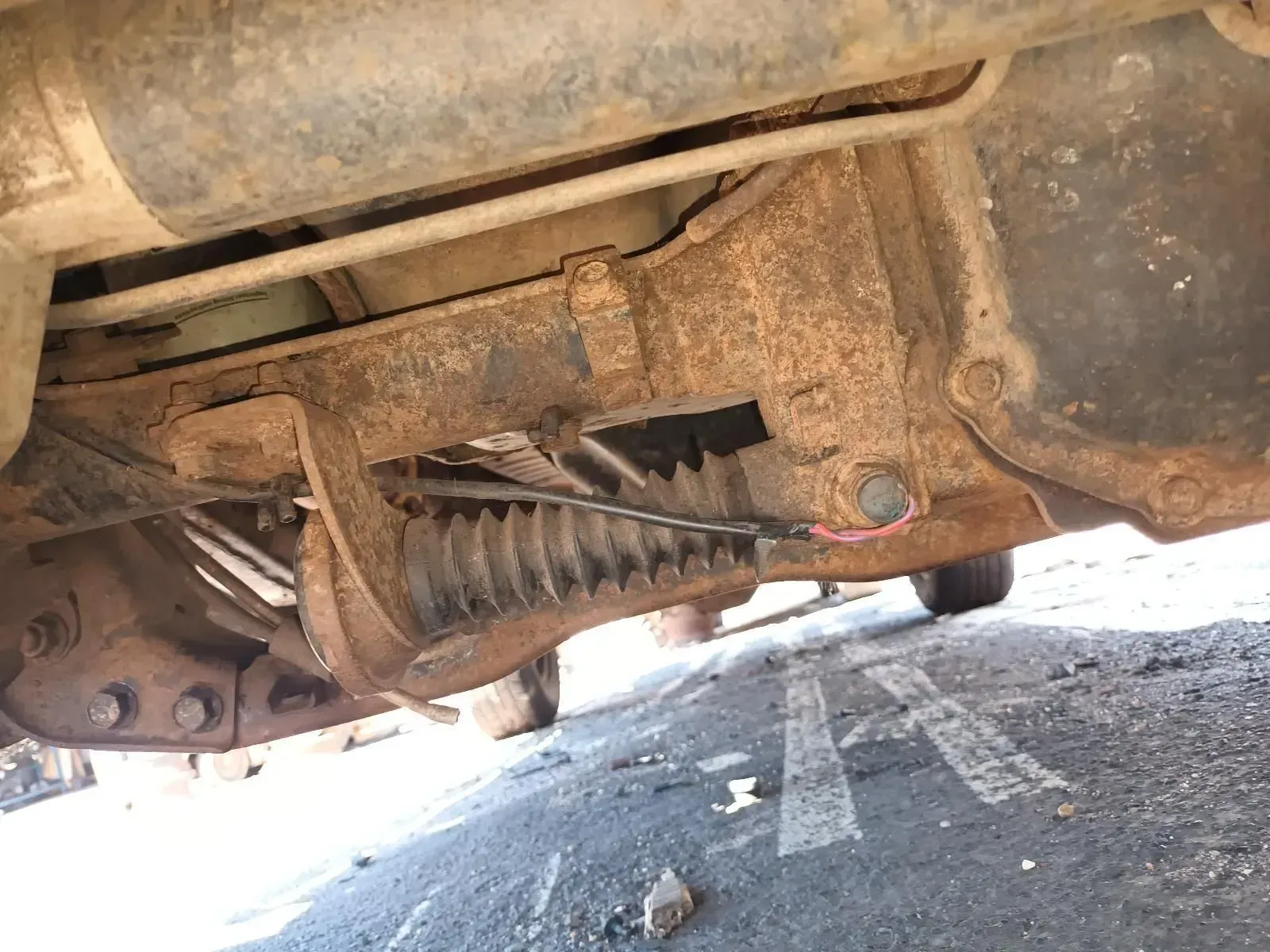 Rusty Truck Undercarriage With a Flexible Joint, a Wire, and Visible Road — South West 4WD Wreckers In Brisbane, QLD