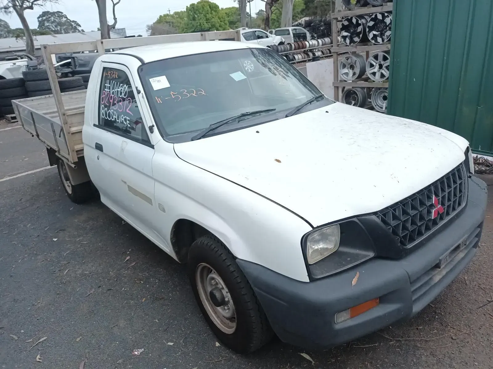 White Mitsubishi Triton Pickup Truck, Parked, on a Paved Lot Near Other Vehicles — South West 4WD Wreckers In Brisbane, QLD