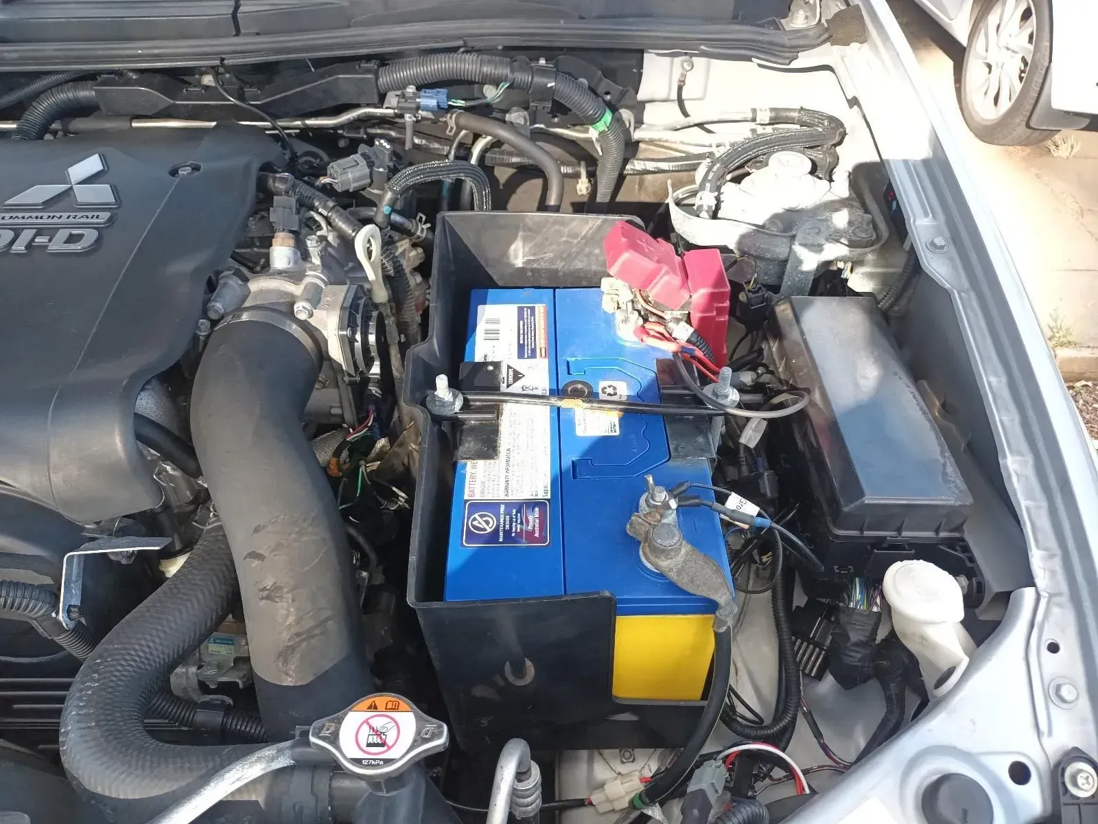 Open Car Engine Compartment With Blue Battery — South West 4WD Wreckers In Brisbane, QLD