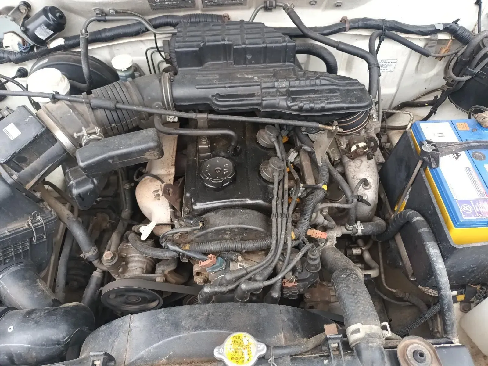 Engine of a Vehicle With Black Components, Hoses, and a Battery — South West 4WD Wreckers In Brisbane, QLD