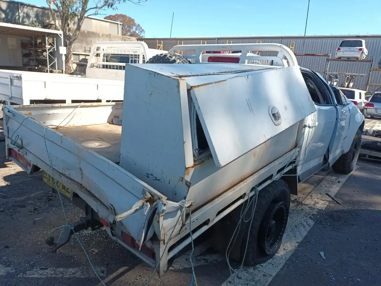 Damaged White Pickup Truck With a Canopy, in a Lot — South West 4WD Wreckers In Brisbane, QLD