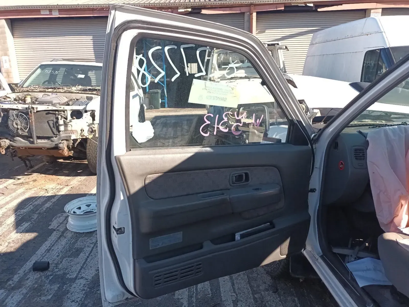Open Door of a Light Gray Pickup Truck in a Salvage Yard. Door Has a Price Tag — South West 4WD Wreckers In Brisbane, QLD