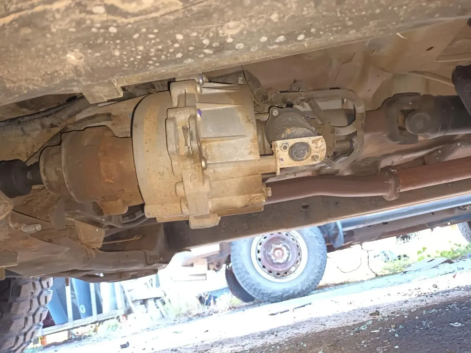 Undercarriage of a Vehicle, Showing the Transfer Case, Driveshaft, and Rear Tyre — South West 4WD Wreckers In Brisbane, QLD
