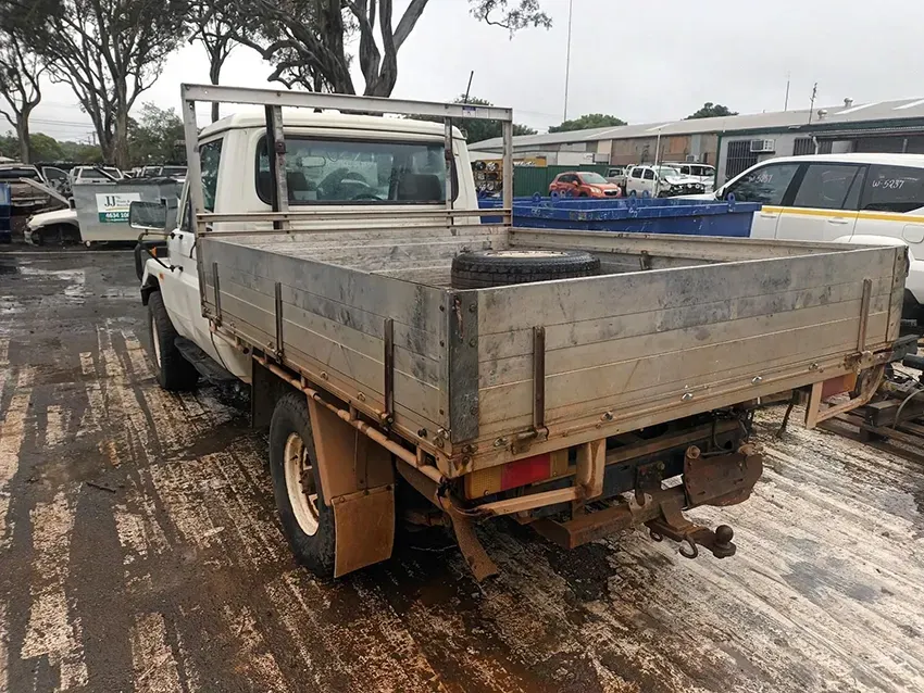 A White Truck With a Flat Bed is Parked in a Parking Lot — South West 4WD Wreckers In Brisbane, QLD