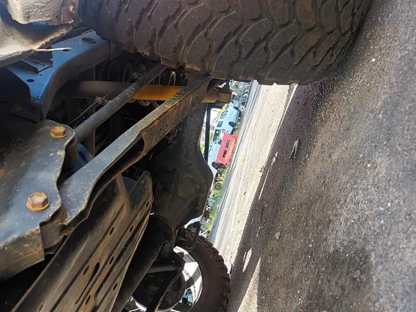 A Close Up of the Underside of a Truck with a Red Car in the Background — South West 4WD Wreckers In Brisbane, QLD