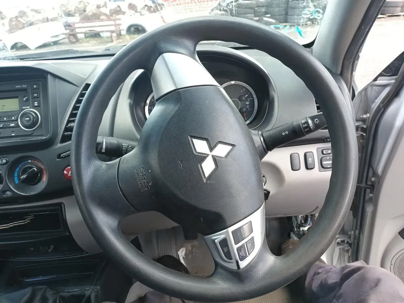 Black Mitsubishi Car Steering Wheel, With Logo and Controls, in a Vehicle Interior — South West 4WD Wreckers In Brisbane, QLD
