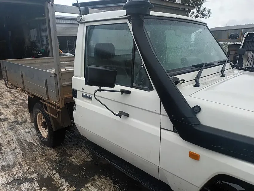 A White Truck With a Snorkel on the Hood is Parked in the Snow — South West 4WD Wreckers In Brisbane, QLD