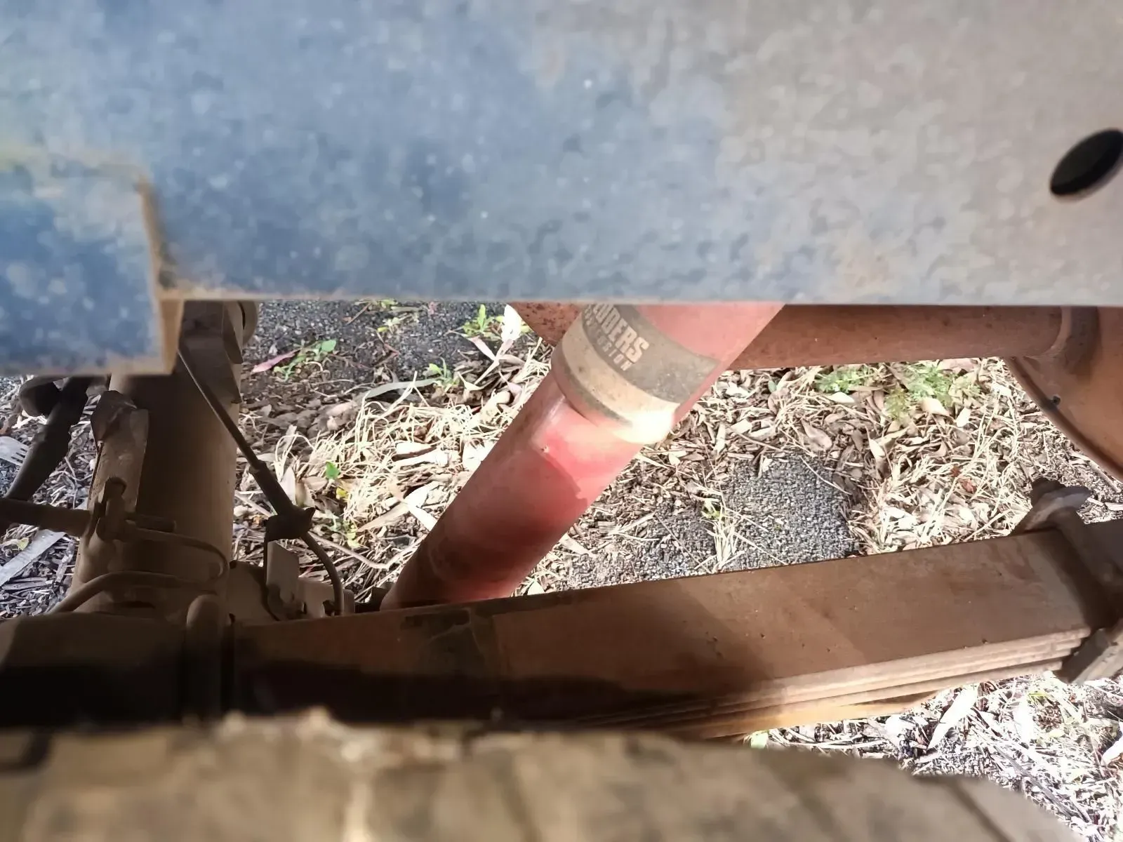 Red Shock Absorber, Part of a Truck's Suspension System, Viewed From Underneath — South West 4WD Wreckers In Brisbane, QLD