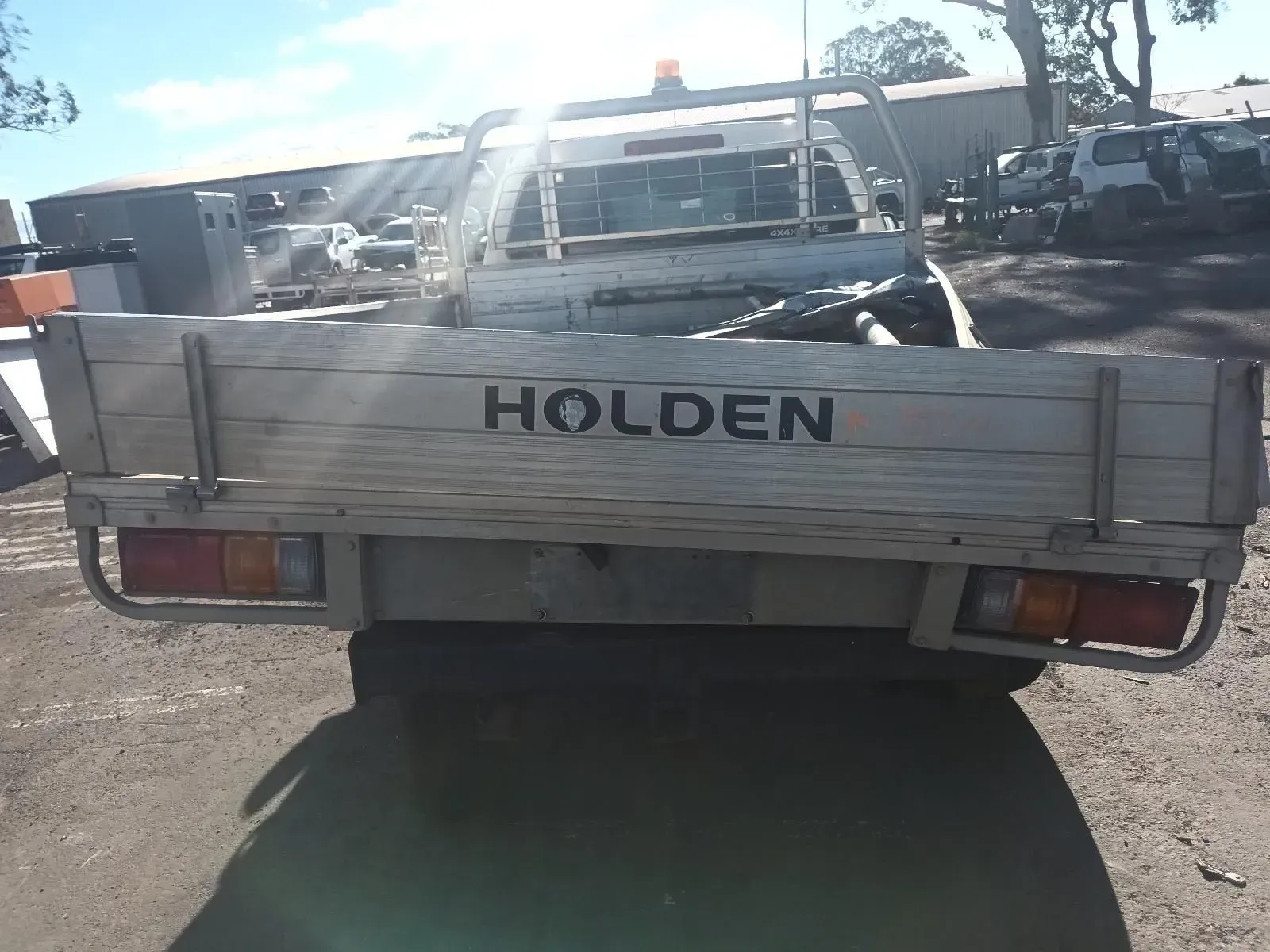 Rear View of a Beige Holden Utility Truck in a Lot on a Sunny Day — South West 4WD Wreckers In Brisbane, QLD
