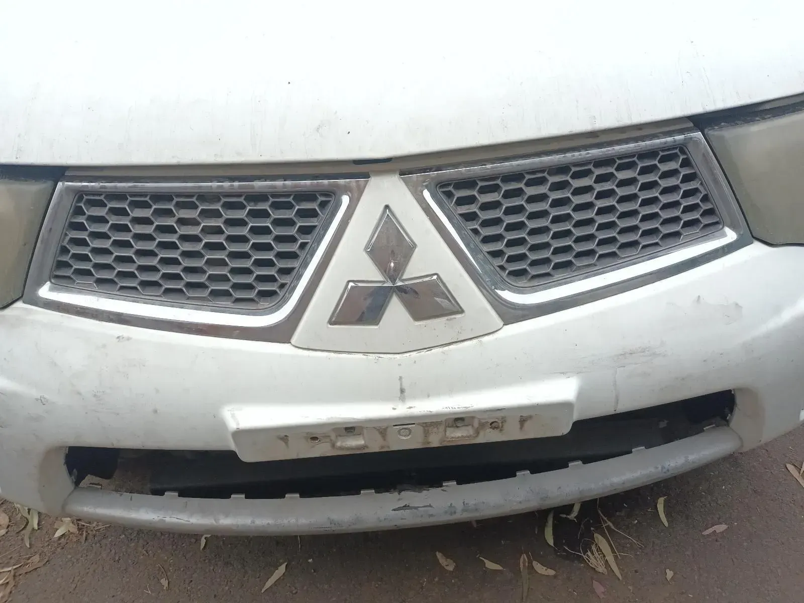 Close-up of a White Mitsubishi Truck Front With the Company Logo in the Grill — South West 4WD Wreckers In Brisbane, QLD
