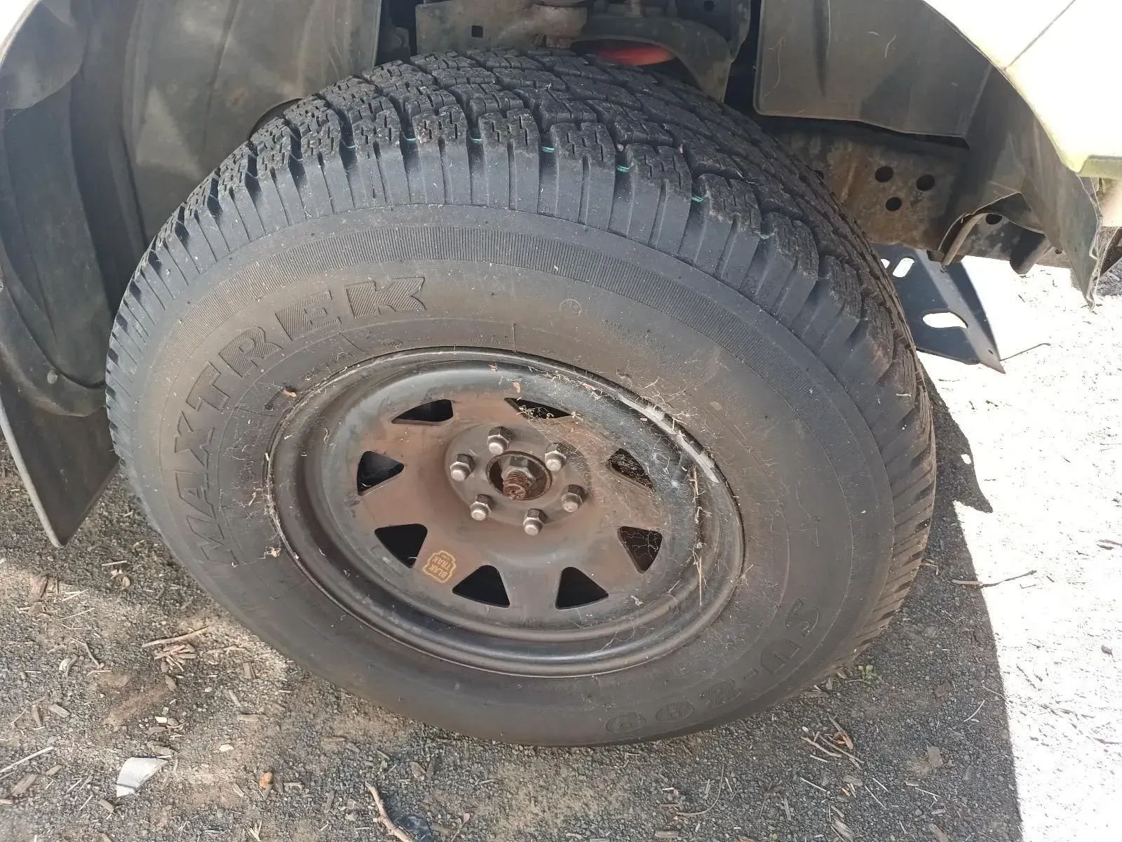 Black Tyre Mounted on a Steel Rim, Attached to a Vehicle, Outdoors — South West 4WD Wreckers In Brisbane, QLD