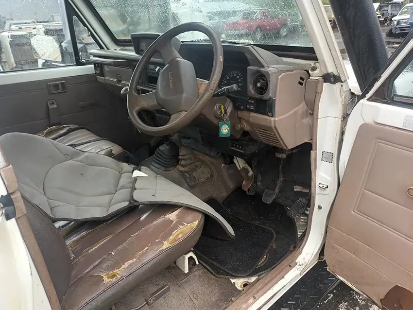 The Interior of a White Car With a Steering Wheel and a Broken Seat Cushion — South West 4WD Wreckers In Brisbane, QLD