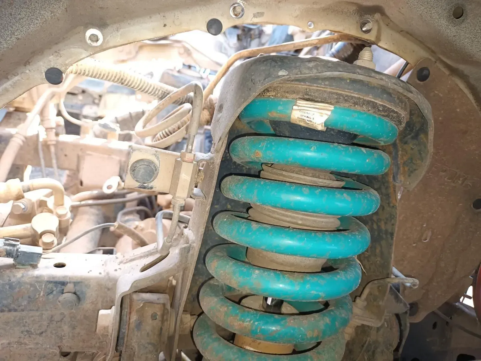 Blue Coil Spring and Shock Absorber on a Vehicle's Wheel Well — South West 4WD Wreckers In Brisbane, QLD