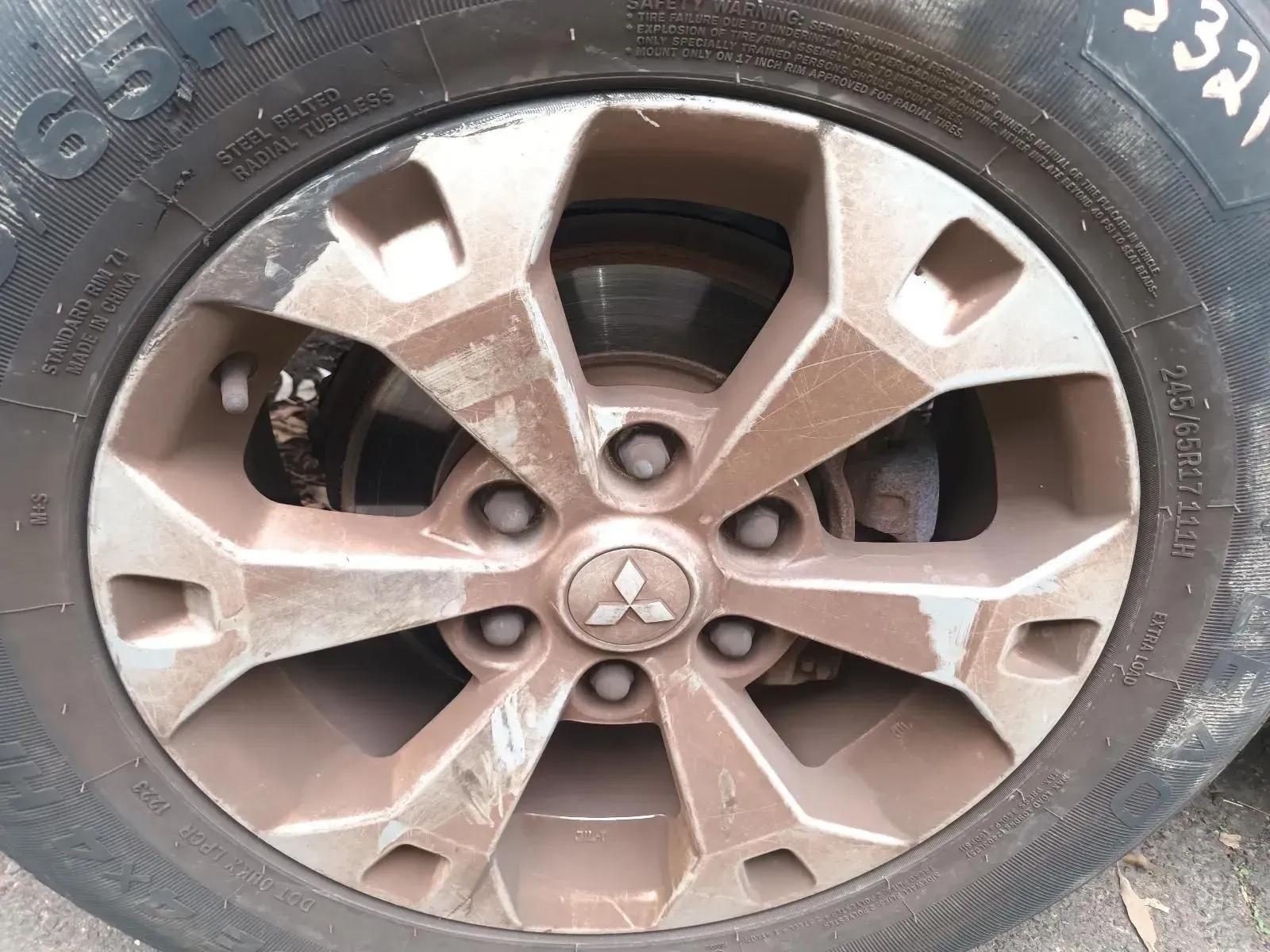 A Dirty Mitsubishi Car Wheel, Covered in Mud, With a Tyre — South West 4WD Wreckers In Brisbane, QLD