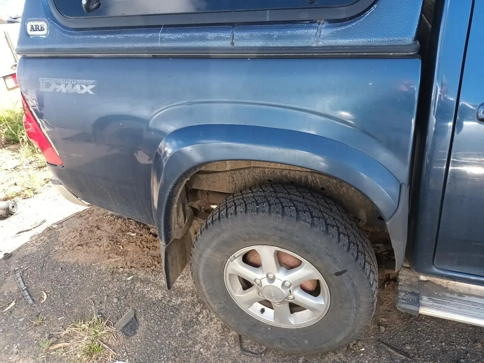 Dark Blue Pickup Truck's Rear Side With a Tyre, a Silver Wheel, and a Canopy — South West 4WD Wreckers In Brisbane, QLD