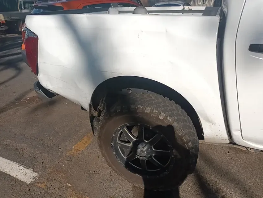 A White Truck with a Black Tire is Parked in a Parking Lot — South West 4WD Wreckers In Brisbane, QLD