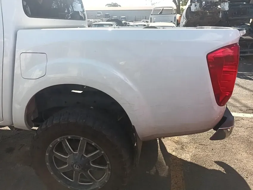 A White Truck with a Red Tail Light is Parked in a Parking Lot — South West 4WD Wreckers In Brisbane, QLD