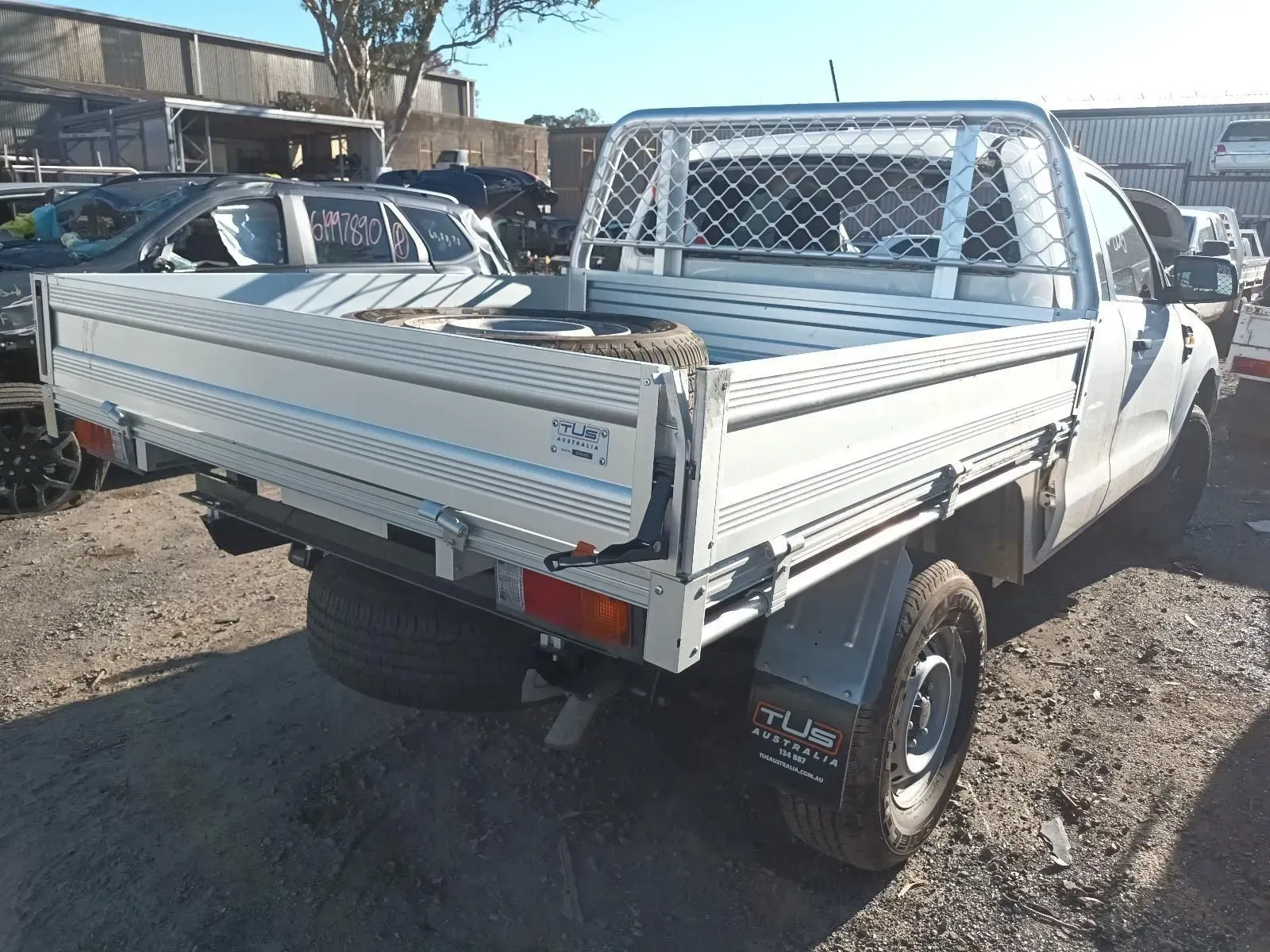 White Pickup Truck With a Flatbed and Safety Cage in a Junkyard — South West 4WD Wreckers In Brisbane, QLD