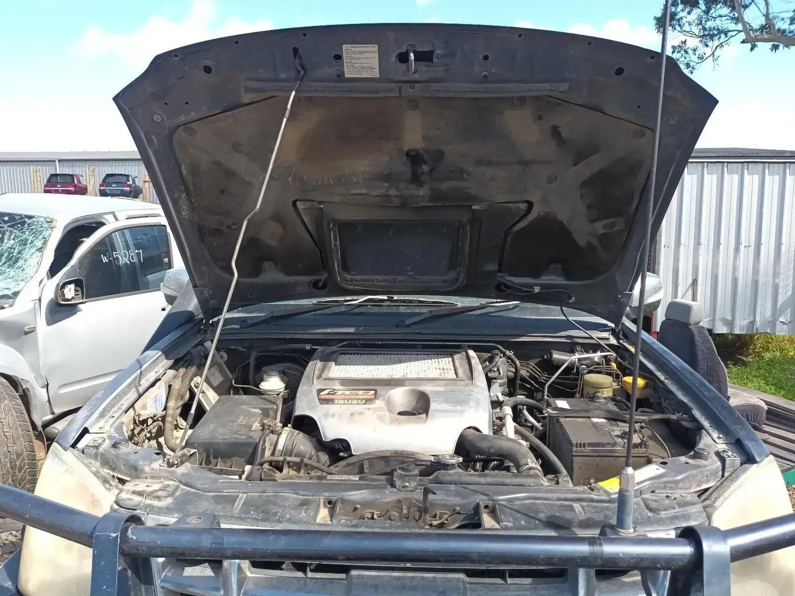 Open Hood of a Dark Gray Truck, Engine Visible, Parked Outdoors in a Salvage Yard — South West 4WD Wreckers In Brisbane, QLD
