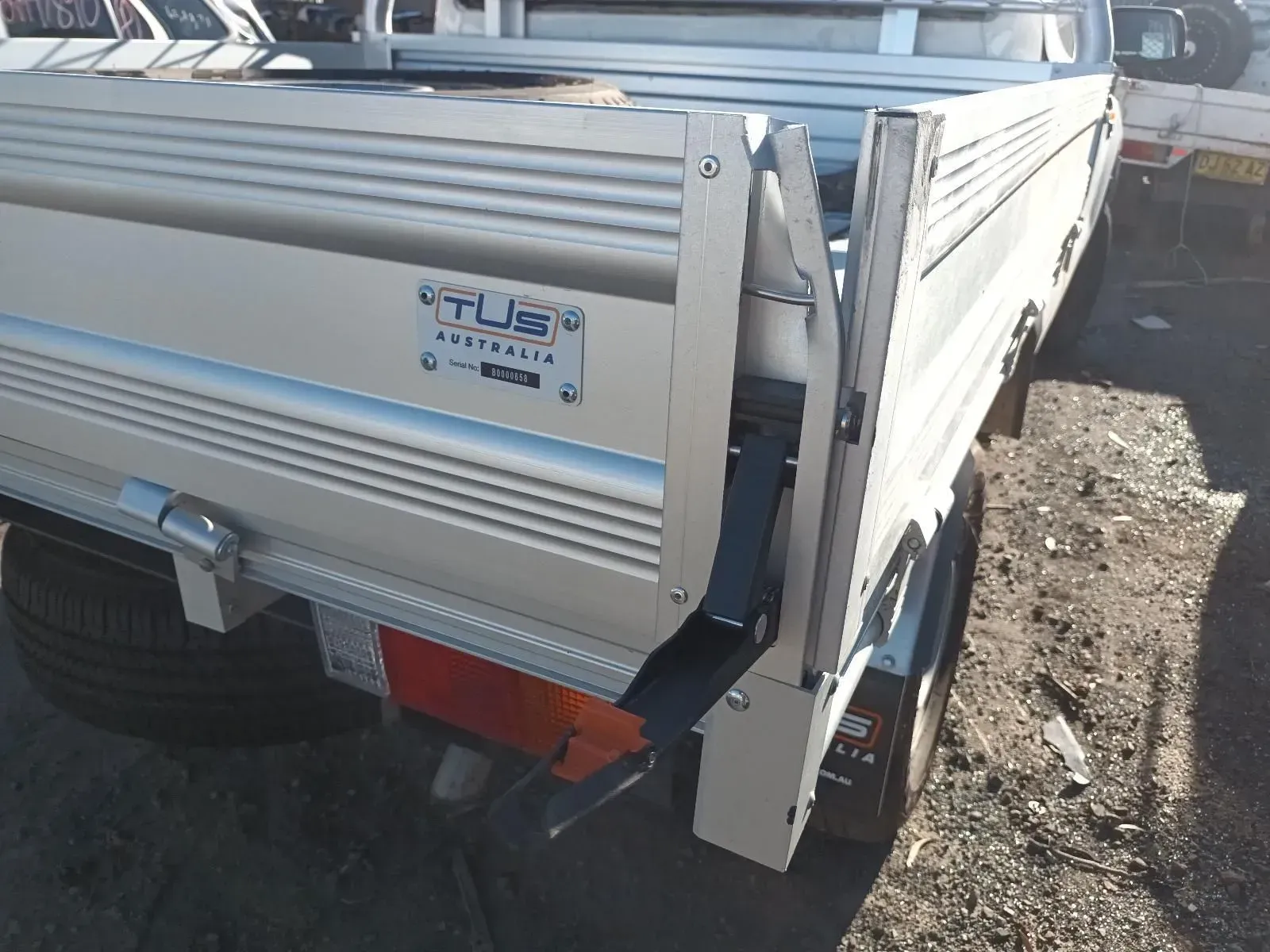 Silver Pickup Truck Bed With a Tjs Manufacturer's Plate, Parked Outdoors — South West 4WD Wreckers In Brisbane, QLD