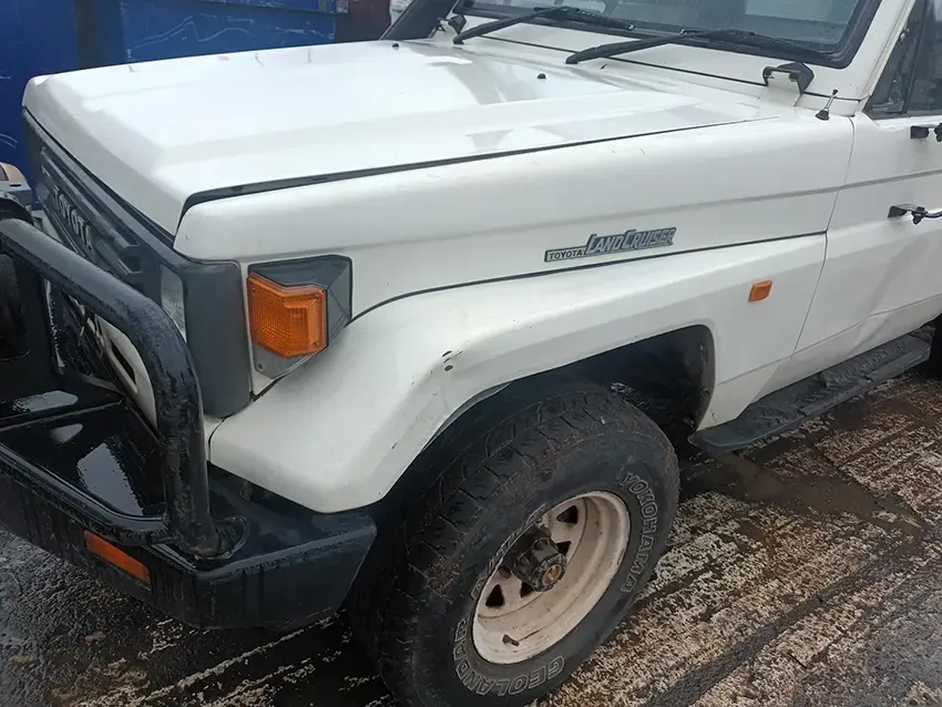 A White Toyota Land Cruiser is Parked on the Side of the Road — South West 4WD Wreckers In Brisbane, QLD
