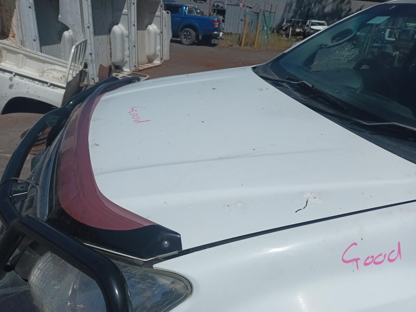A White Truck With a Red Hood is Parked in a Parking Lot — South West 4WD Wreckers In Brisbane, QLD