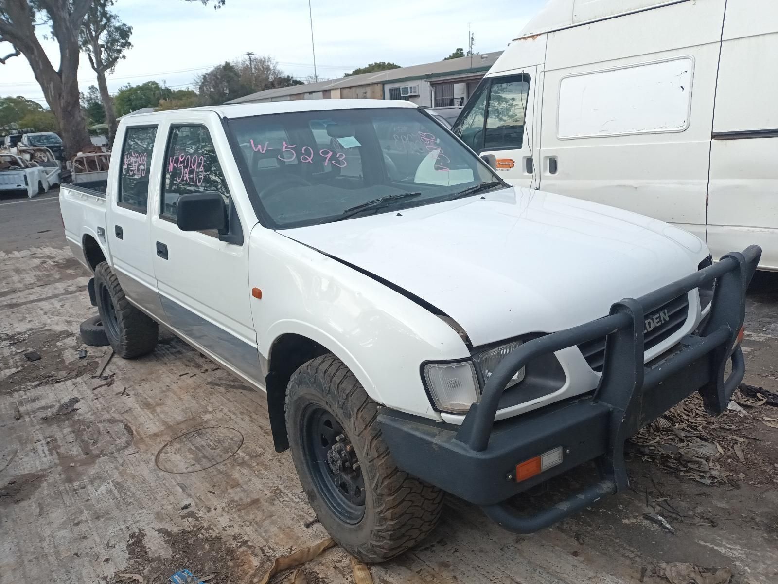 A White Pickup Truck is Sitting in the Dirt Next to a White Van — South West 4WD Wreckers In Harristown, QLD