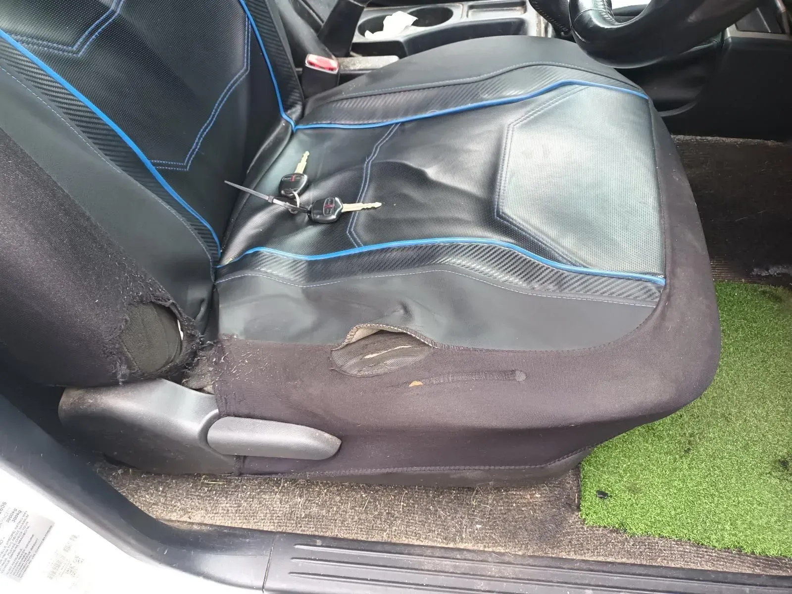 Damaged Black Car Seat With Blue Trim and Holes; Keys Are on the Seat — South West 4WD Wreckers In Brisbane, QLD