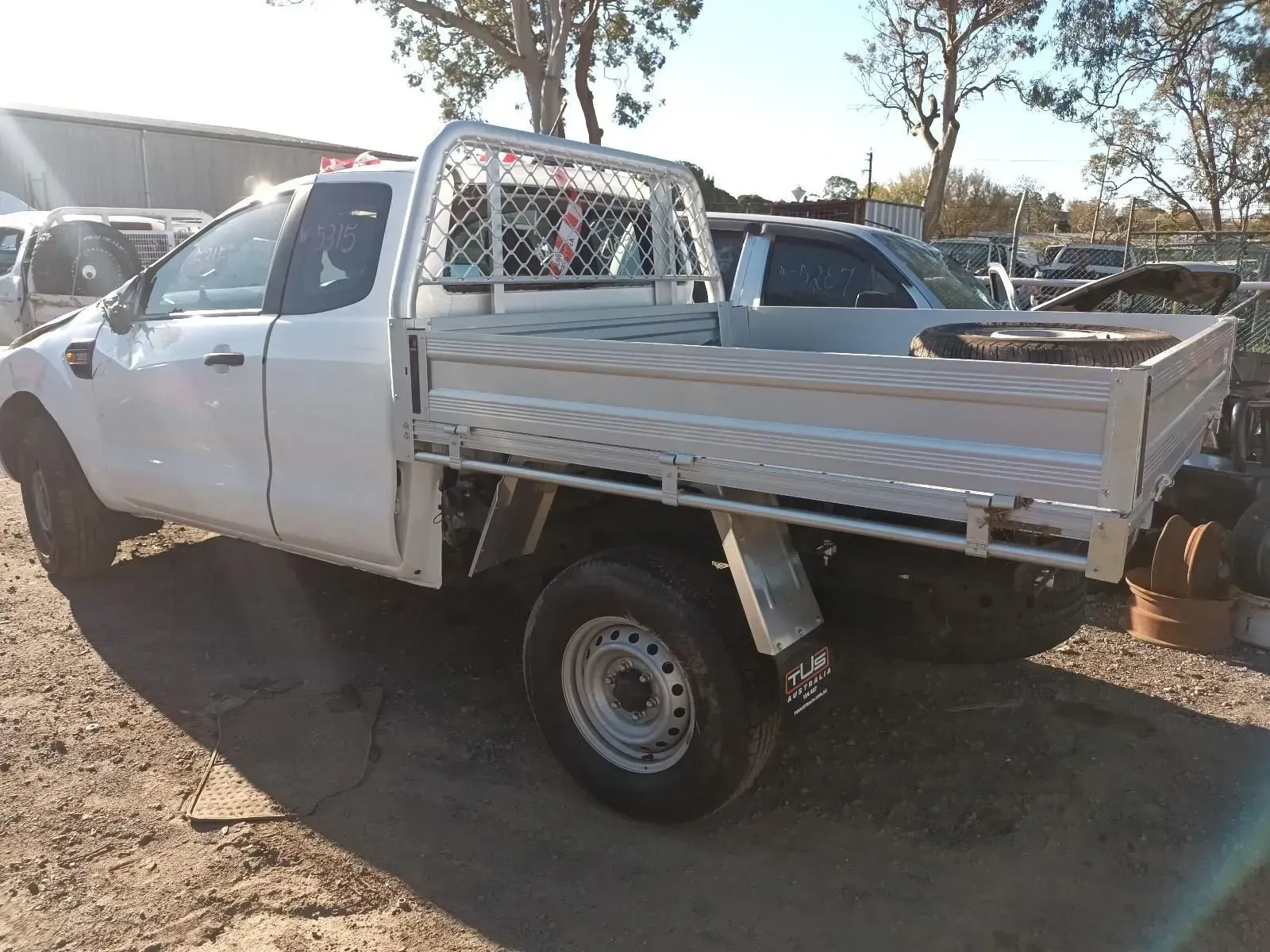 White Pickup Truck With a Flatbed in a Yard — South West 4WD Wreckers In Brisbane, QLD