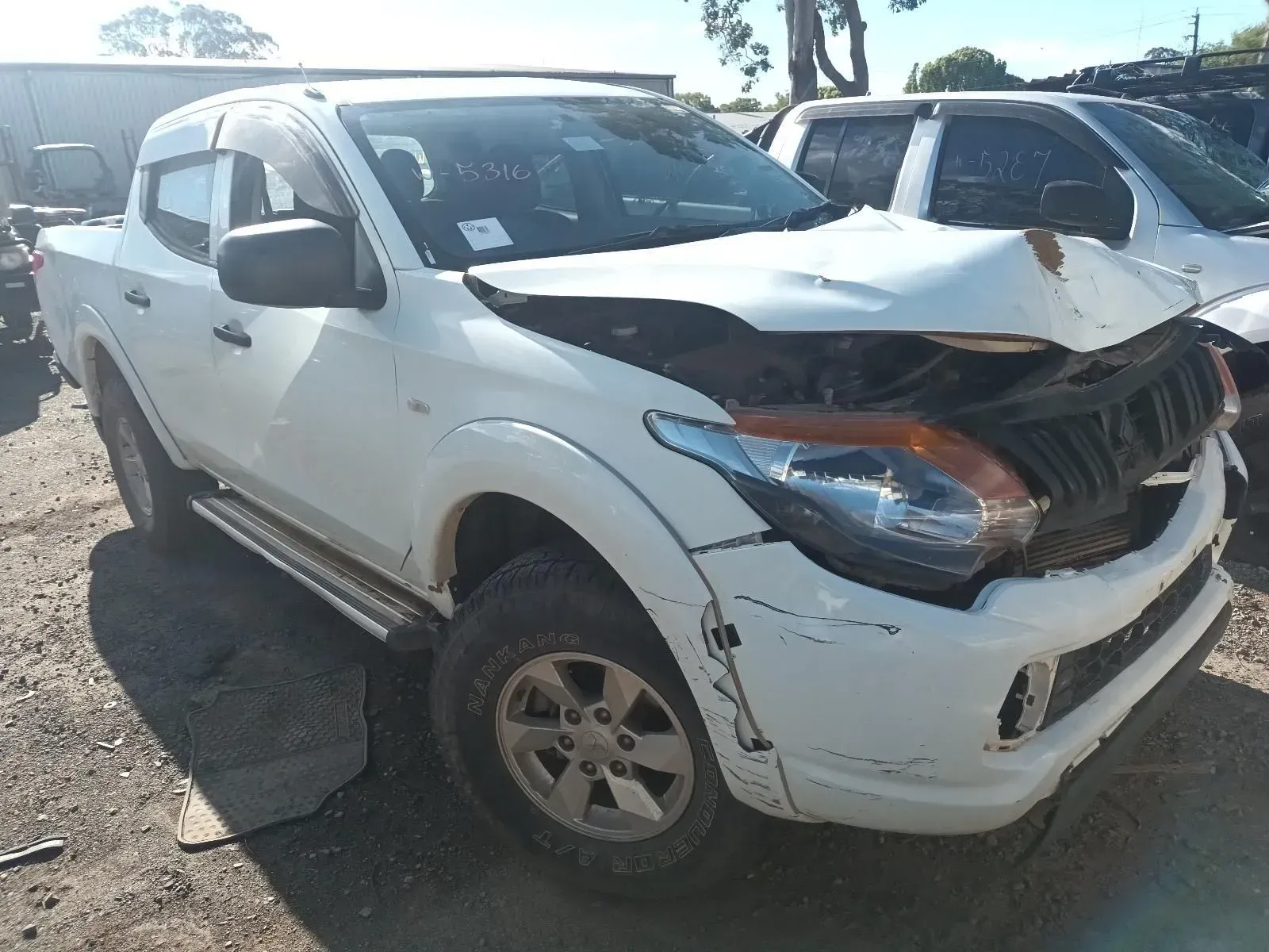 White Pickup Truck With Significant Front-end Damage in a Salvage Yard — South West 4WD Wreckers In Brisbane, QLD