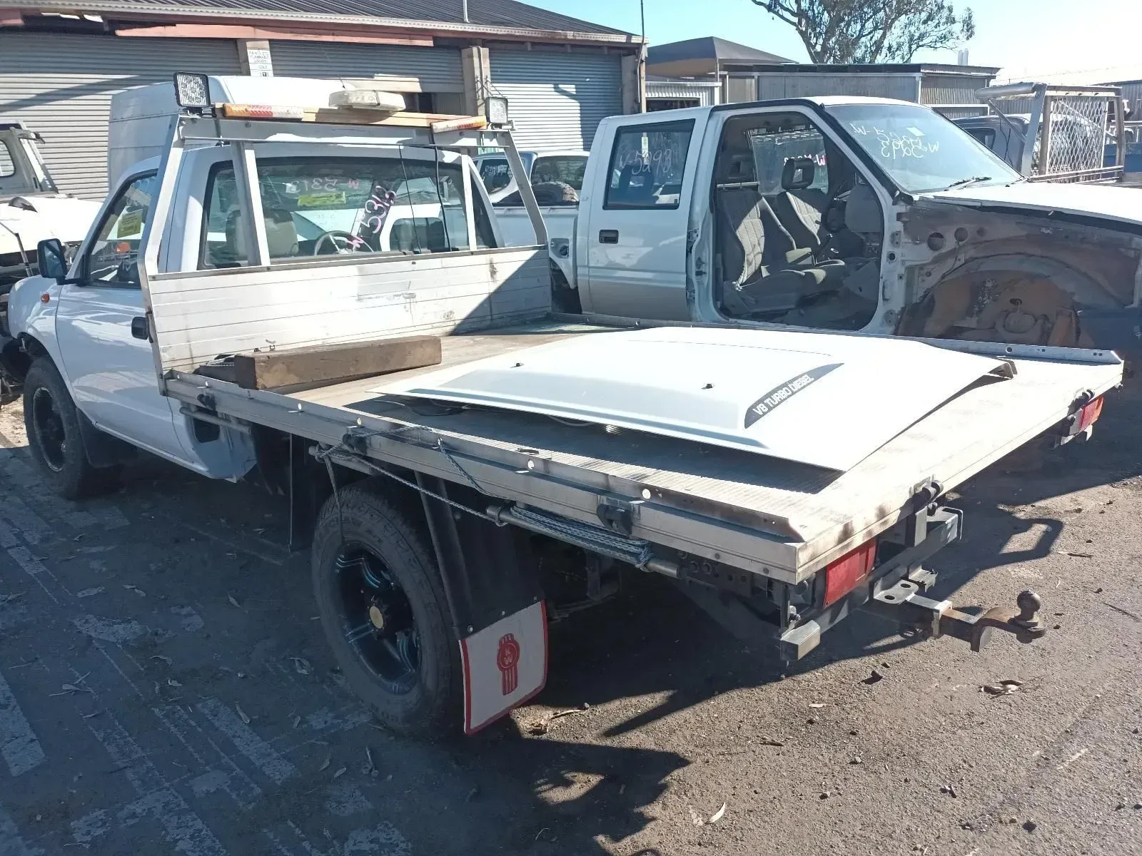 White Flatbed Truck in a Junkyard, Missing Doors and Parts — South West 4WD Wreckers In Brisbane, QLD