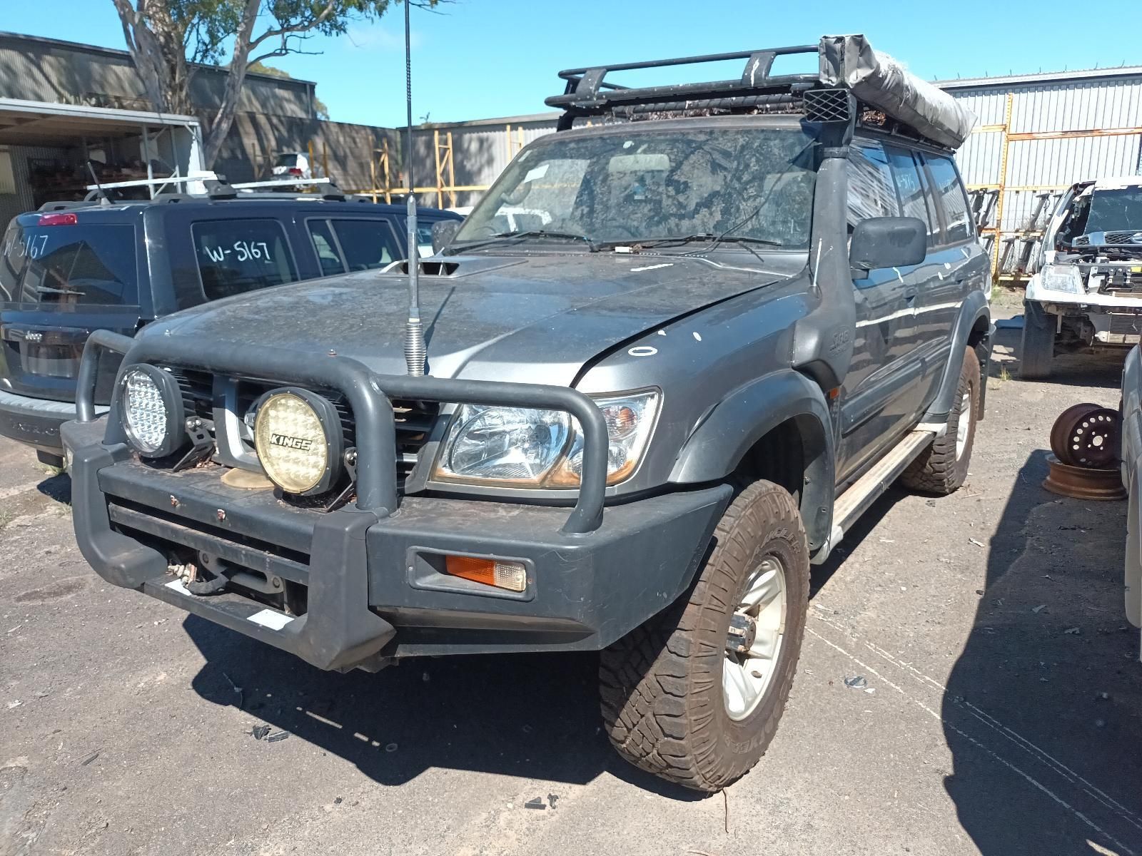 A Gray SUV with a Tent on Top of It is Parked in a Parking Lot — South West 4WD Wreckers in Harristown, QLD 