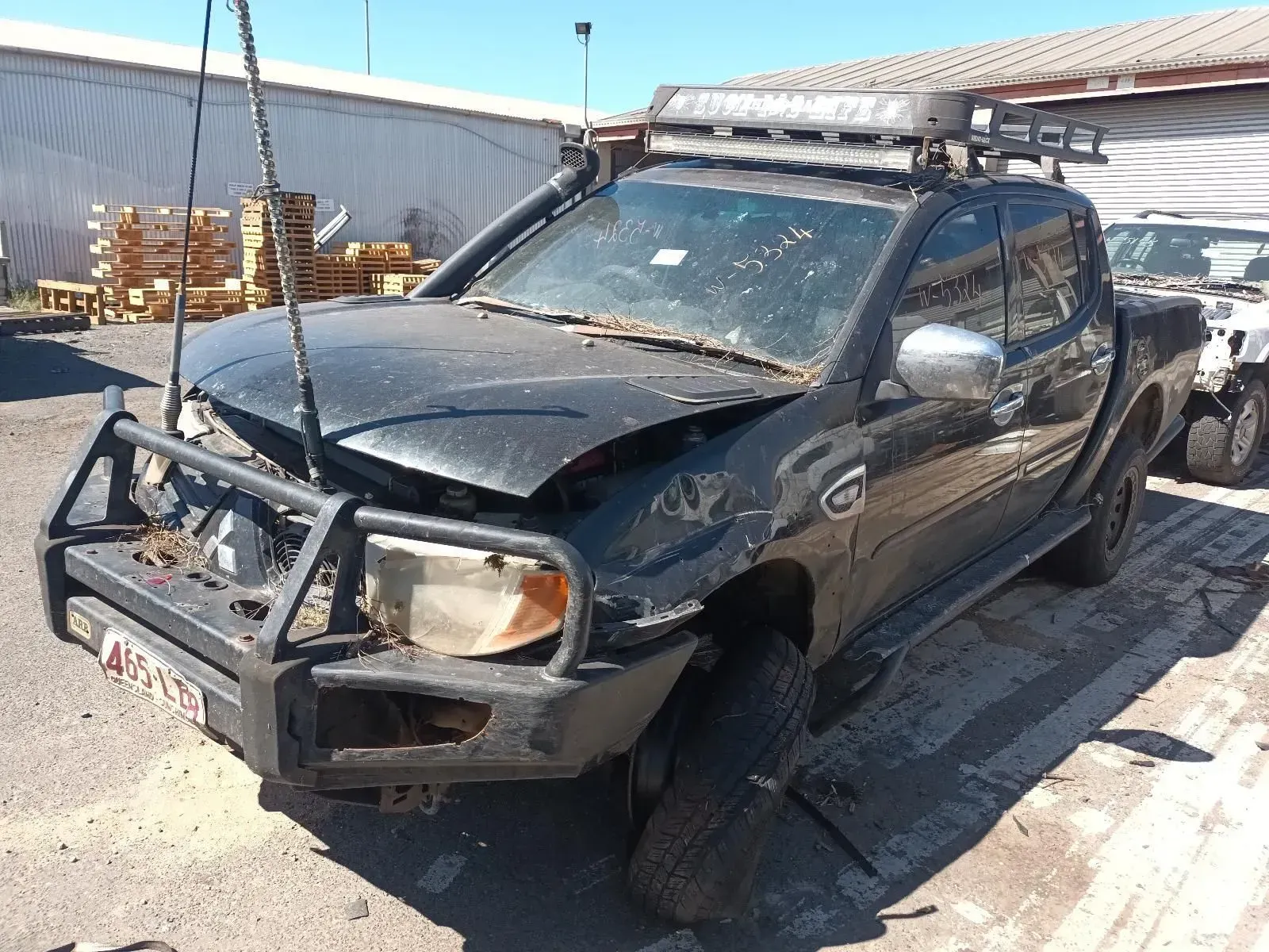 Damaged Black Pickup Truck at a Salvage Yard, Showing Front-end Collision Damage — South West 4WD Wreckers In Brisbane, QLD