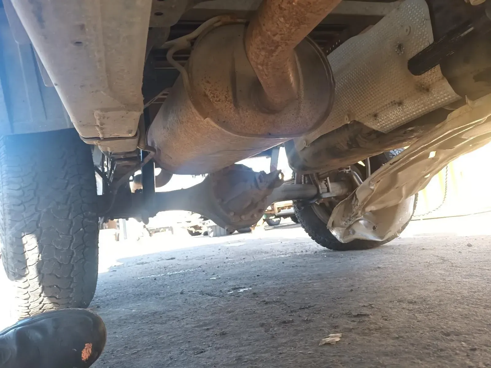 Undercarriage of a Vehicle With a Rusty Muffler and Rear Axle Visible — South West 4WD Wreckers In Brisbane, QLD