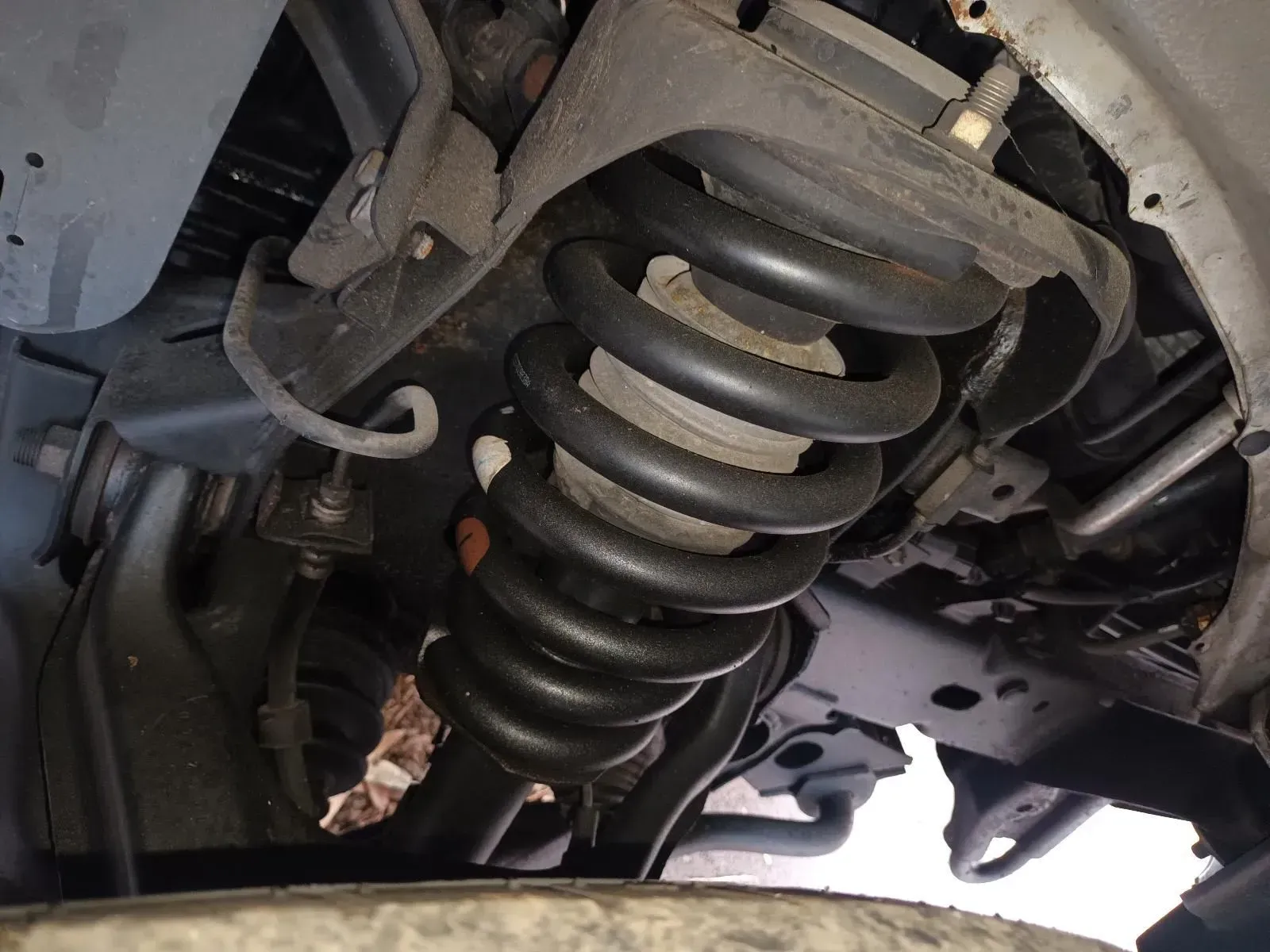 Black Suspension Coil Spring in a Car's Undercarriage — South West 4WD Wreckers In Brisbane, QLD