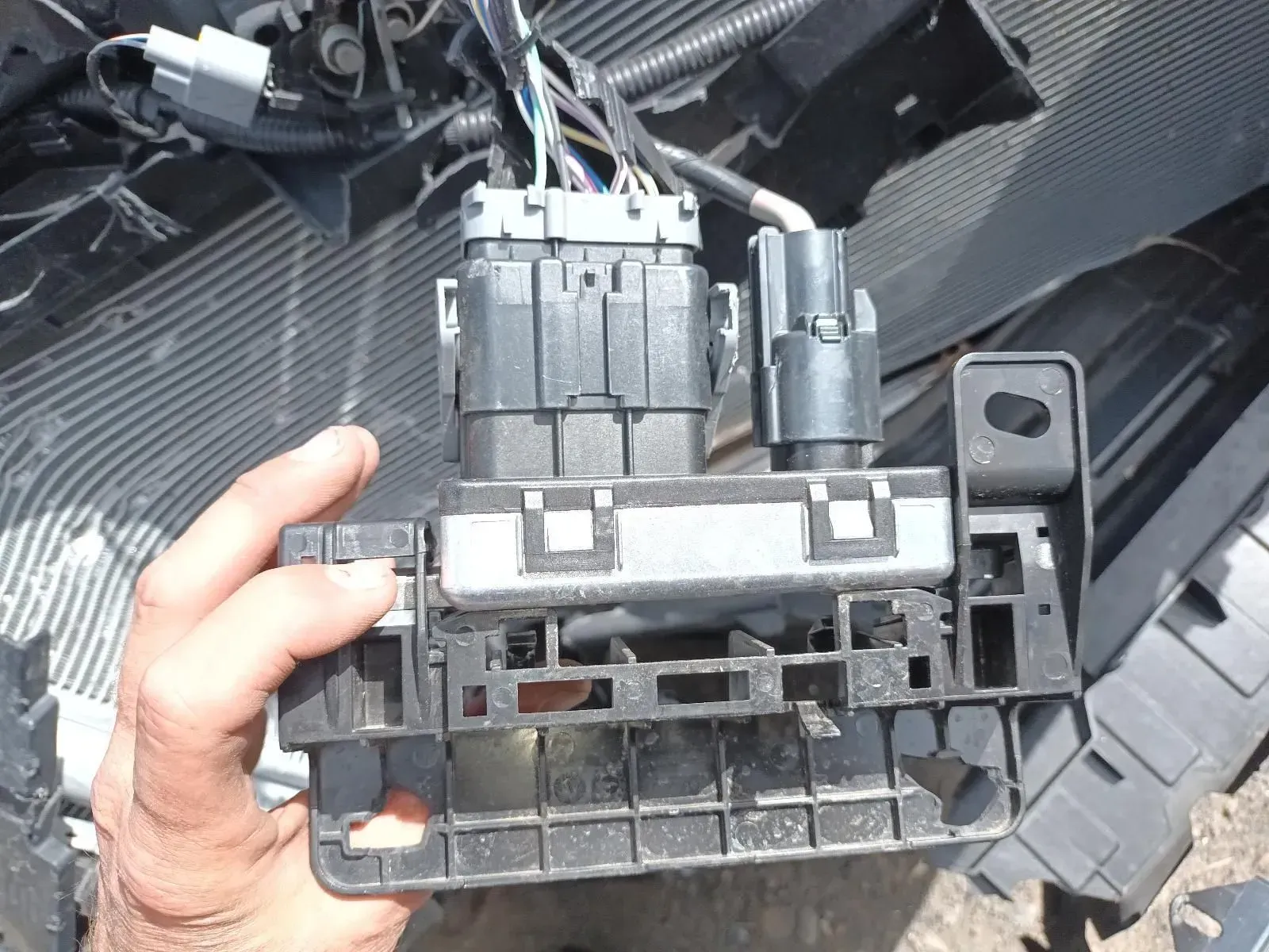 Hand Holding a Black Automotive Electrical Component — South West 4WD Wreckers In Brisbane, QLD