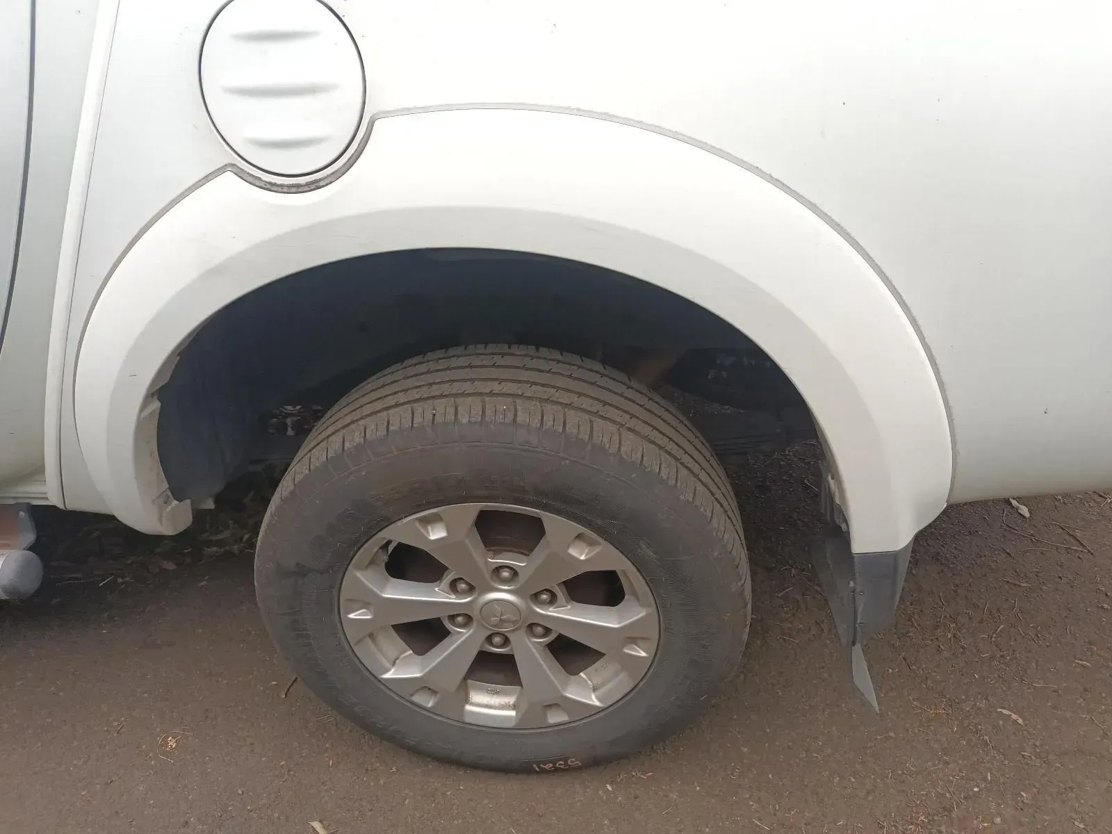 Silver Car's Rear Wheel With a Black Tyre. White Fender — South West 4WD Wreckers In Brisbane, QLD