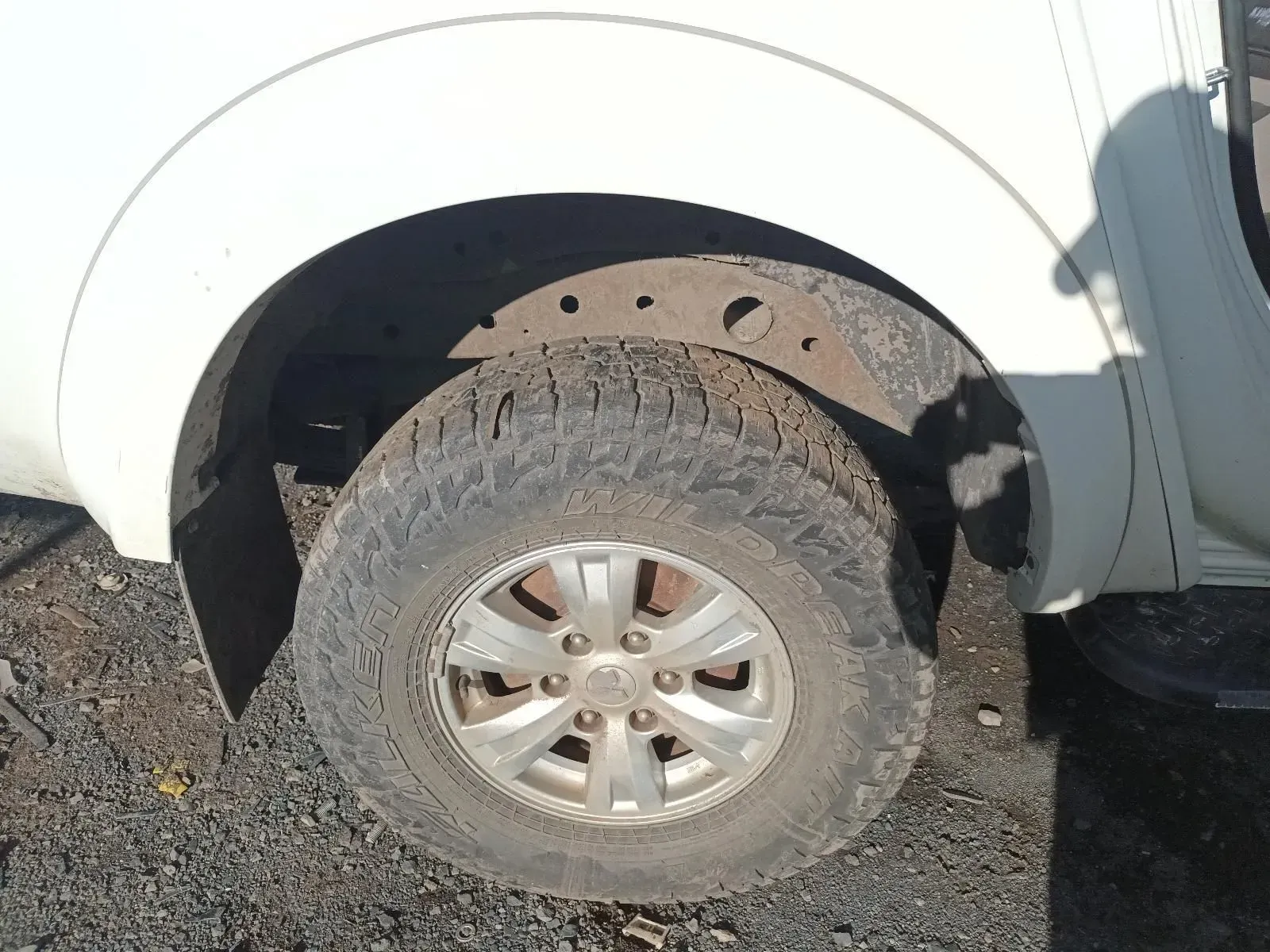 White Truck Wheel With a Worn Tyre, Visible in an Outdoor Setting — South West 4WD Wreckers In Brisbane, QLD
