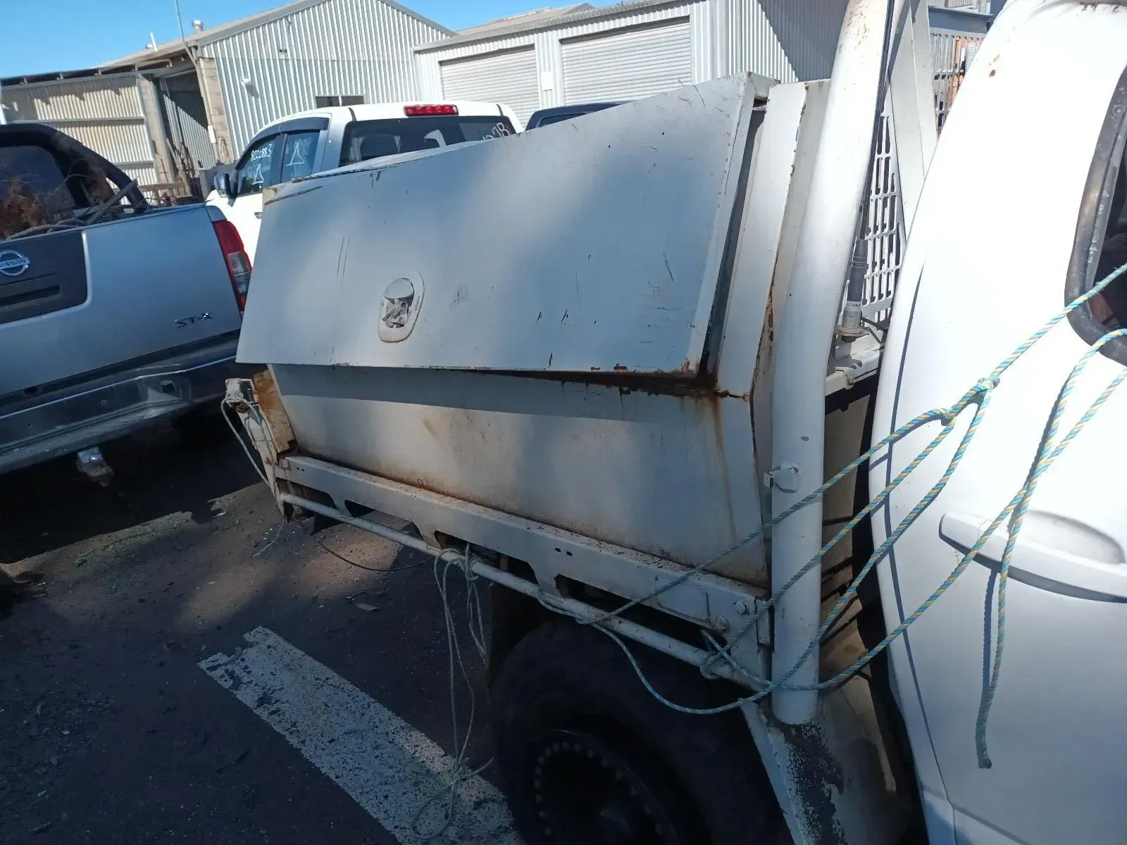 White Utility Truck Bed With Storage Compartment and Surrounding Vehicles — South West 4WD Wreckers In Brisbane, QLD