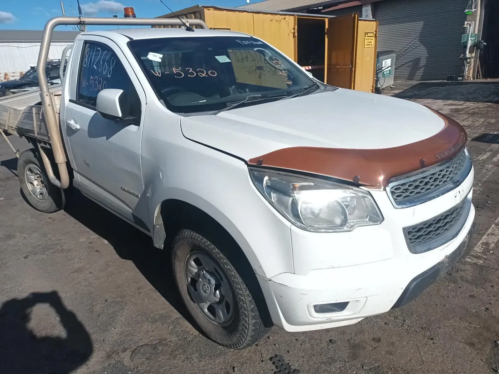 White Chevy Colorado Pickup Truck With a Brown Hood Protector in a Salvage Yard — South West 4WD Wreckers In Brisbane, QLD
