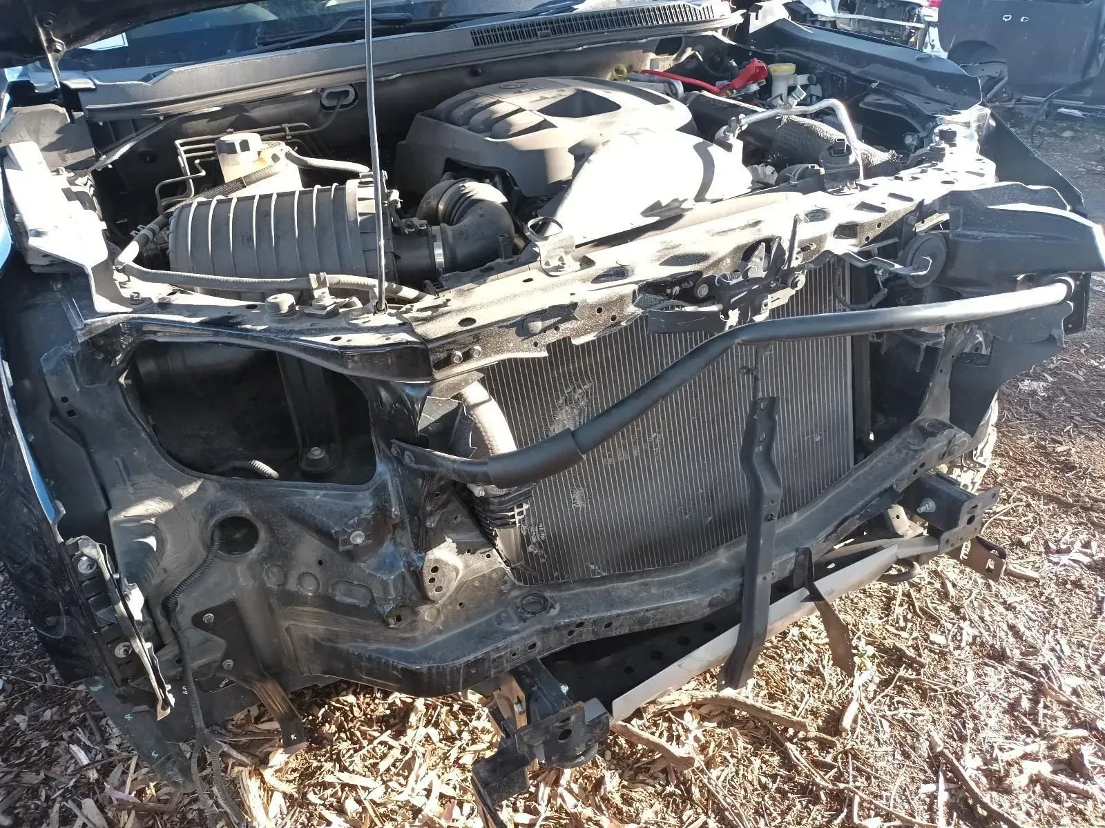 Damaged Car Front End With Exposed Engine and Radiator in a Junkyard — South West 4WD Wreckers In Brisbane, QLD
