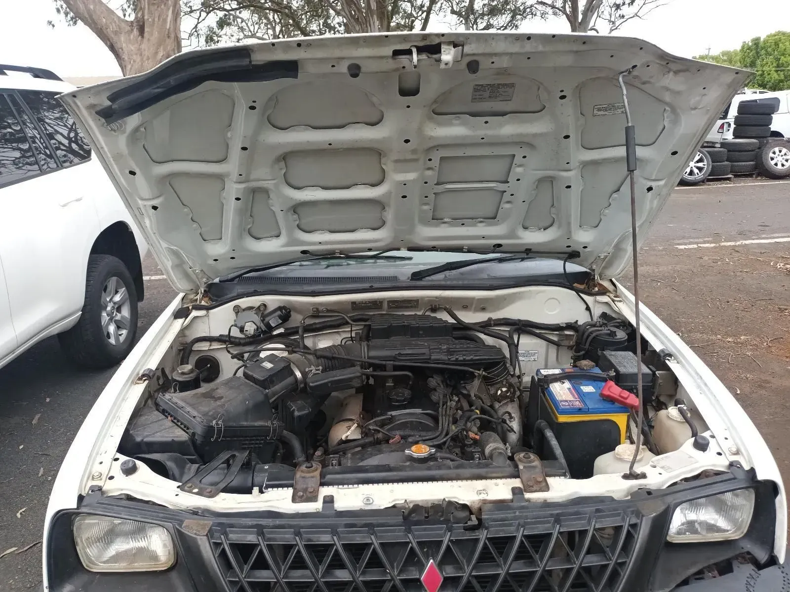 White Car With Hood Open, Engine Visible, Parked in a Lot — South West 4WD Wreckers In Brisbane, QLD