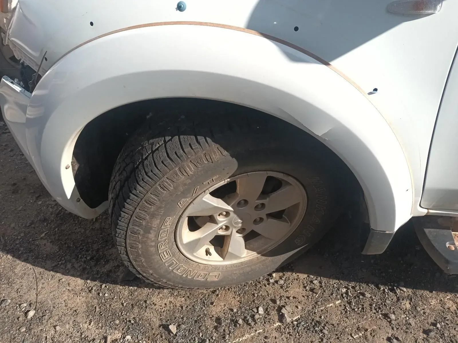 White Car Wheel and Fender on Dirt Ground — South West 4WD Wreckers In Brisbane, QLD