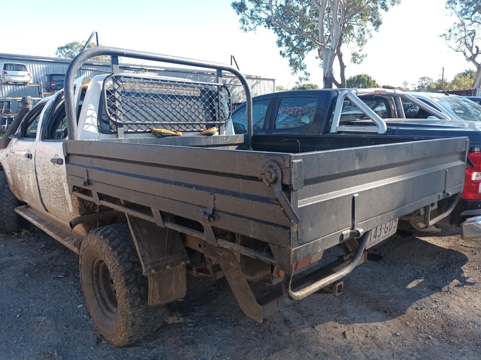 A Dirty Truck With a Tray on the Back is Parked in a Parking Lot — South West 4WD Wreckers In Harristown, QLD