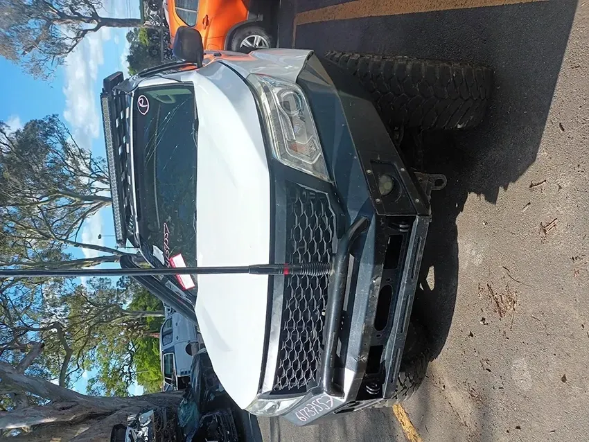 A White Truck is Parked in a Parking Lot with Trees in the Background — South West 4WD Wreckers In Brisbane, QLD