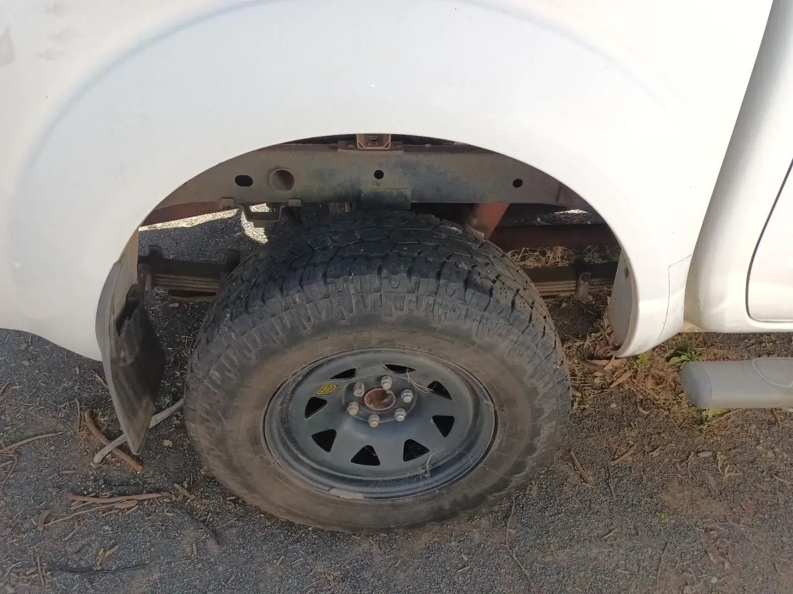 White Pickup Truck Tyre and Wheel Against a White Fender — South West 4WD Wreckers In Brisbane, QLD