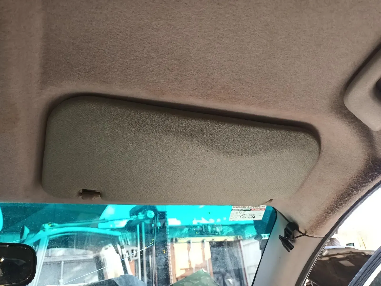a Car's Interior: Sun Visor Down, Tan Material, Against Light-colored Headliner — South West 4WD Wreckers In Brisbane, QLD