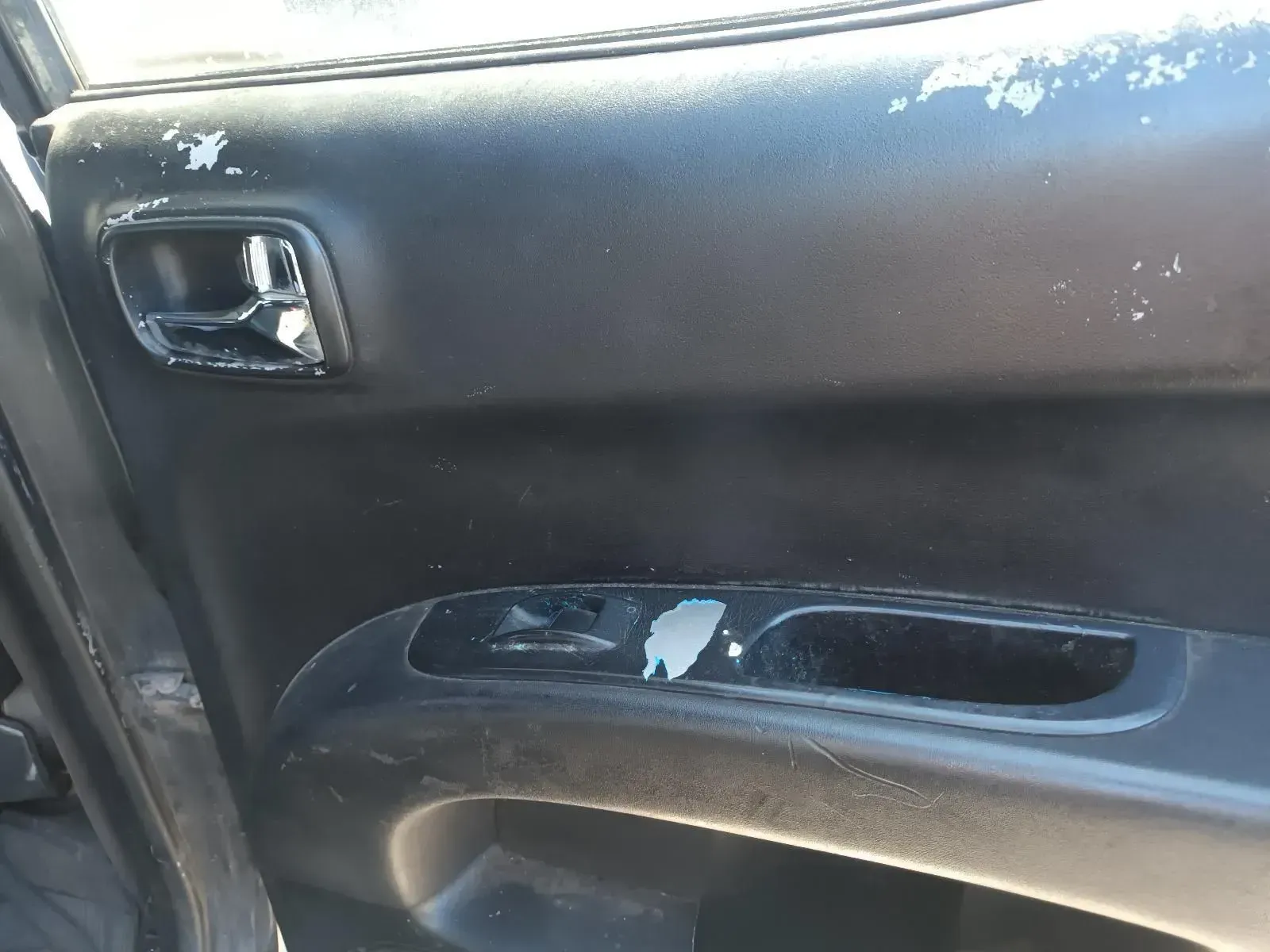 Close-up of a Worn Black Car Door Panel With Peeling Paint and Chrome Handle — South West 4WD Wreckers In Brisbane, QLD