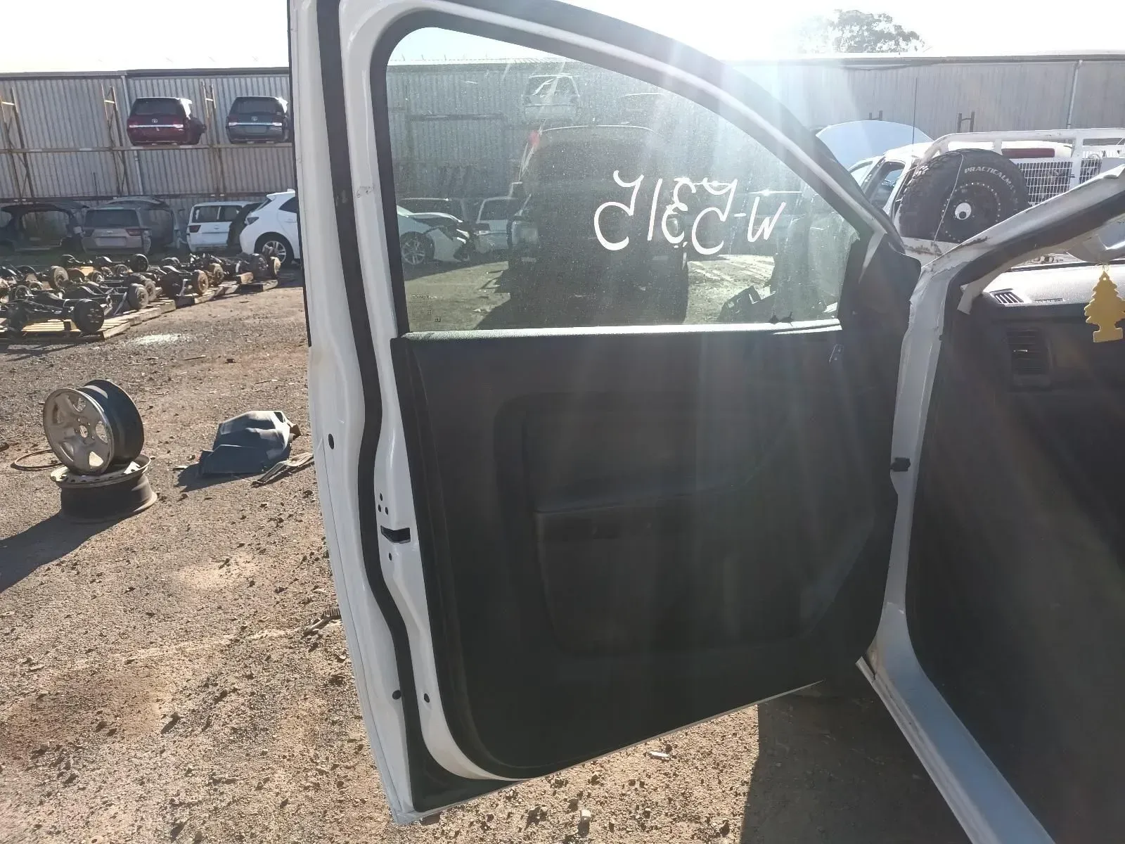 Open White Car Door in a Salvage Yard With Debris and Other Vehicles — South West 4WD Wreckers In Brisbane, QLD